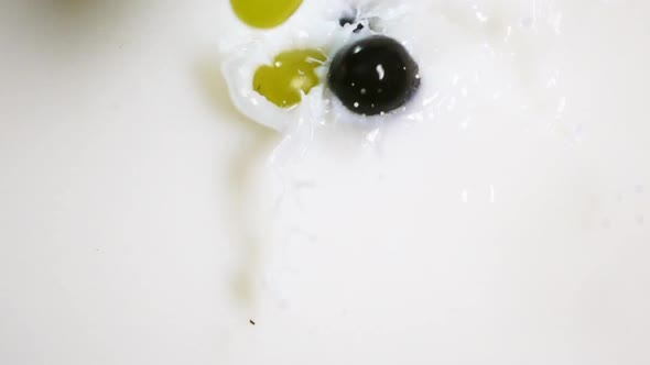 Berries of Grape Falling Down Into Milk