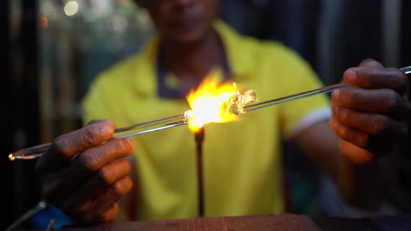 Senior man forming melted glass