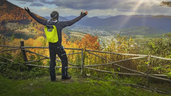 Young Man Raising His Hands on Mountain View Point