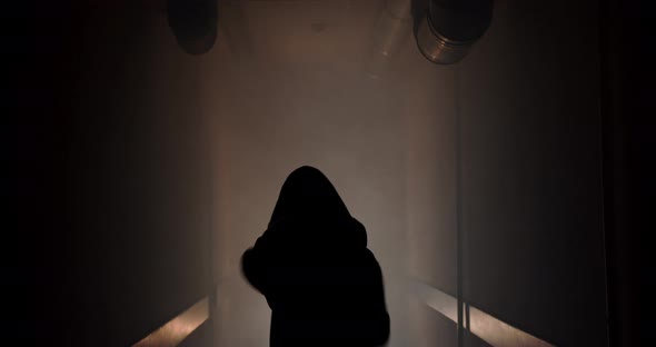 Boxer boxing with a shadow in a semi-dark corridor with a backlight behind his back, slow motion.