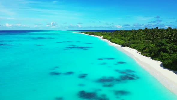 Aerial above scenery of tropical tourist beach lifestyle by blue green sea with bright sandy backgro