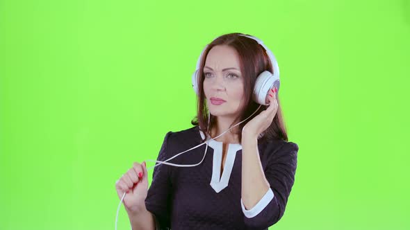 Woman Listening To Music on Headphones. Green Screen