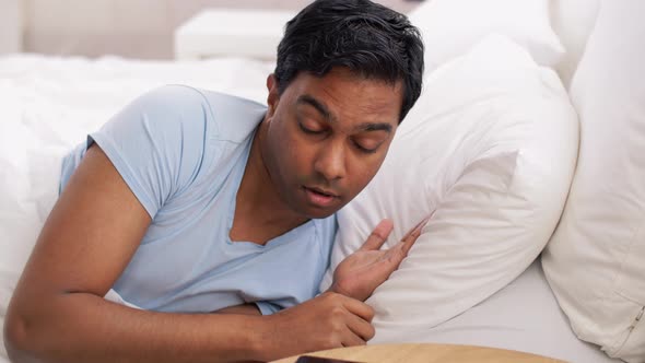 Indian Man Suddenly Awaking and Looking at Phone