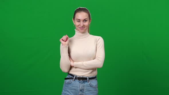 Beautiful Confident Young Woman Waving at Camera Winking on Green Screen