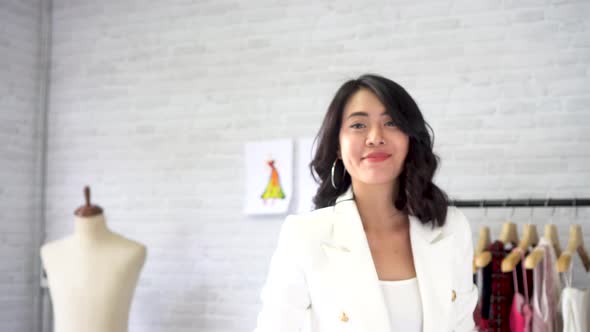 Confident Asian Young Female Dressmaker Having Arms Crossed with Sewing Machine at Workshop