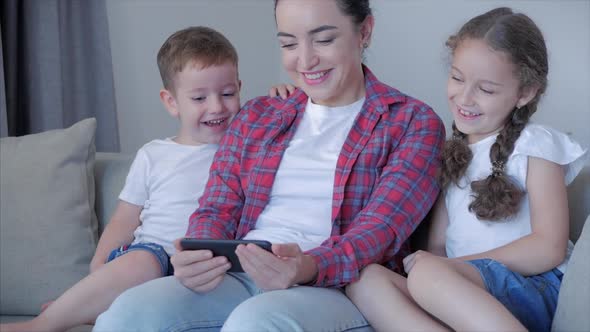 Happy Family,mom and Cute Little Children Watch the Phone,mom Plays with Children at Home,relaxing