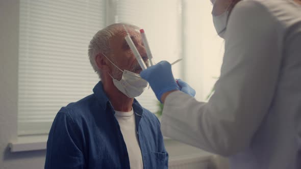 Nurse Taking Nasal Swab Covid Test in Elderly Man Closeup