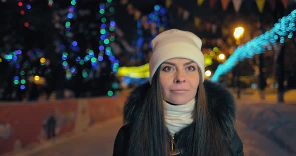 Happy Woman Walks in the Winter Park in the Evening