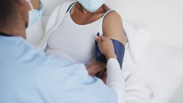 African american female doctor and senior female patient in face masks