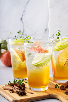 Refreshing apple cocktail or mocktail with ice and sliced apples