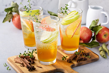 Refreshing apple cocktail or mocktail with ice and sliced apples