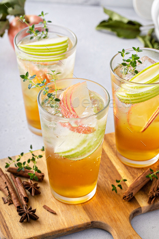 Refreshing apple cocktail or mocktail with ice and sliced apples