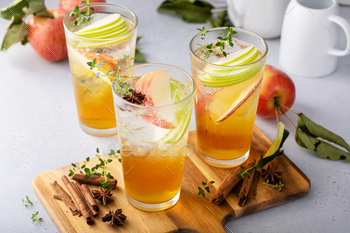 Refreshing apple cocktail or mocktail with ice and sliced apples