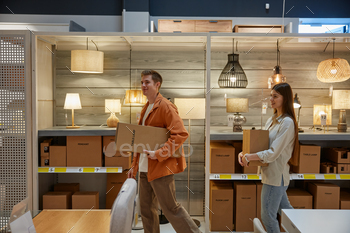 Young family couple shopping at modern lamp store market
