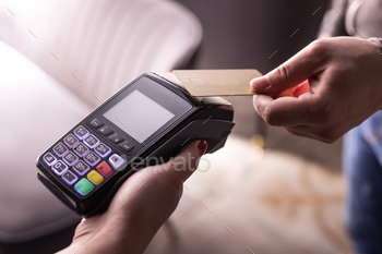 NFC credit card payment. Woman paying with contactless credit card with NFC technology