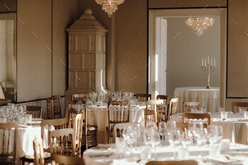 Stunning banquet room showcasing elegant wooden chairs and tables draped in pristine white cloths.