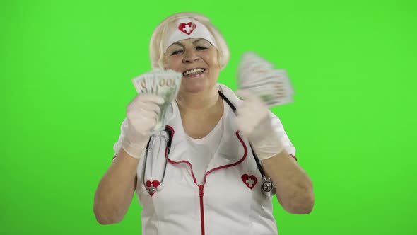 Elderly Caucasian Female Doctor Receives Money. Concept of Corruption
