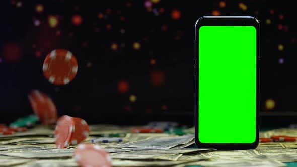 Gaming Chips Falling on Dollars on Background of Smartphone With Green Screen