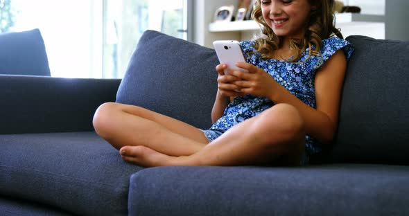 Girl using mobile phone in living room