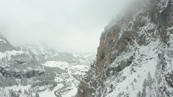 Aerial jib up of mountain ridge with the top covered in mist