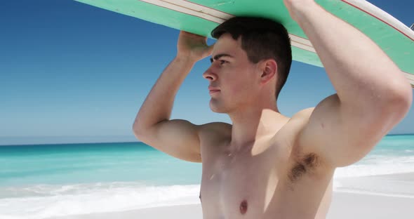 Man holding a surfboard on his head