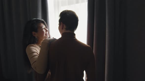 Couple Standing By Window In Hotel