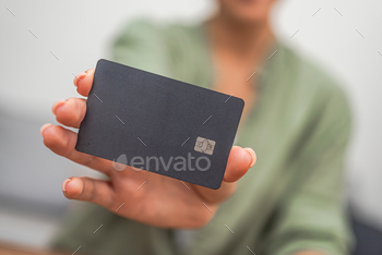 Dark credit card for making offline and online payments in stores in hands of female buyer