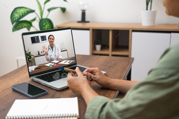 Patient engaging in a telemedicine session with a doctor on a laptop at home