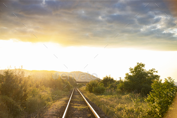 Train tracks leading into the sunset
