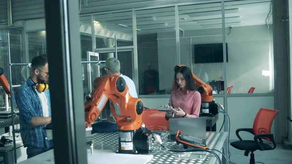 Modern Science Laboratory. Engineers Work with Robotic Arm at Laboratory
