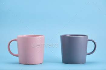 Pink and blue mug on a blue background. The struggle of opposites, the game of color.