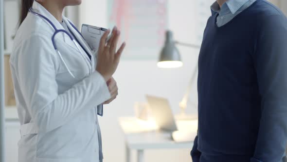 Female Doctor Shaking Hands and Speaking with Male Patient