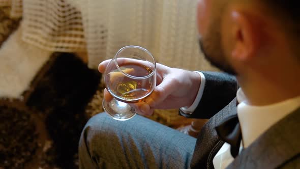 Unrecognizable Businessman Holding Glass with Whiskey Tasting Alcohol Drink