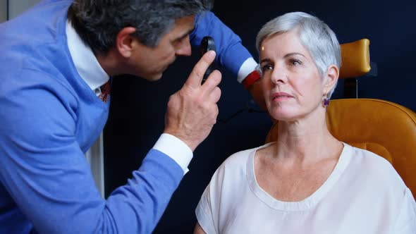Optometrist examining patient eyes with ophthalmoscope 4k