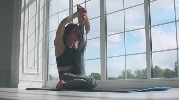 Young Female Doing Yoga in a White Room Filled with Light the Girl Performs Yoga Stands Near the