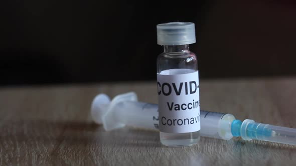 Coronavirus Vaccine Vial And Syringe. On The Surface Of The Table. Close Up.