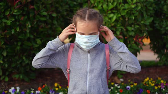 A Teenage Girl Wears a Protective Medical Disposable Mask on the Street