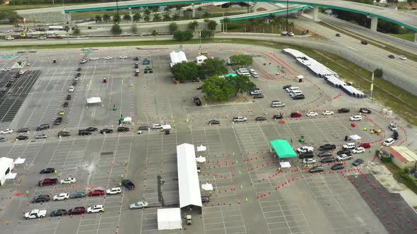 Covid 19 test site Miami parking lot line of cars waiting