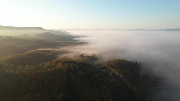 Aerial view of sunrise with fog above mountains