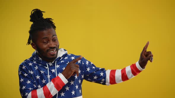 Portrait of Cheerful African American Man Smiling Pointing to the Right at Yellow Background