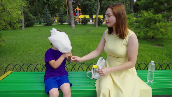 Mother and Son Eating Cotton Candy in Park