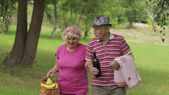 Family Weekend Picnic. Active Senior Old Grandparents Couple in Park. Husband and Wife Walk Together