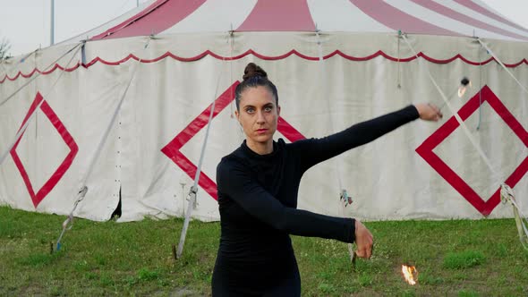 Female circus artist juggling with fire