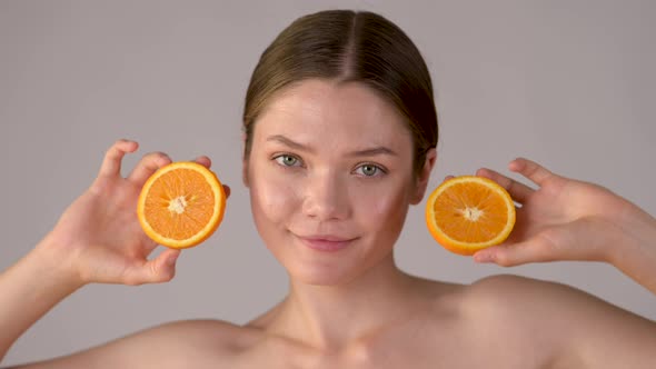 Young healthy girl with slices of orange citrus fruit