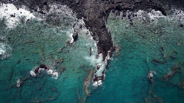 Beautiful ocean view taken by a drone. from blue ocean to the black rocks on the beach, waves come a