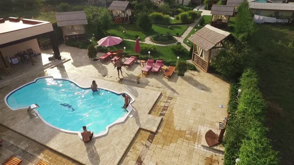 Four Topless Caucasian Males Sitting Standing Near Pool in Cottage