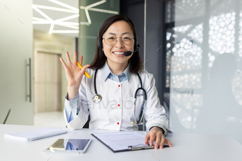 Asian female doctor providing telemedicine services with a smile in clinic office