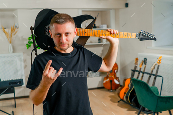 rock performer with an electric guitar in a recording studio before a performance or rehearsal
