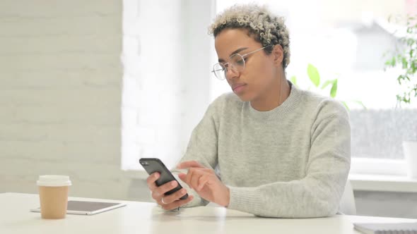 Attractive African Woman Using Smartphone in Office