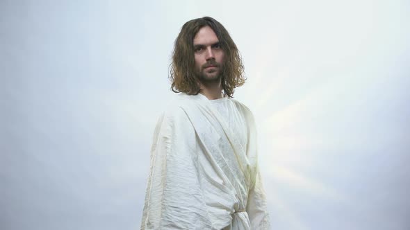 Jesus Turning to Camera on Shiny Background, Looking With Compassion and Love